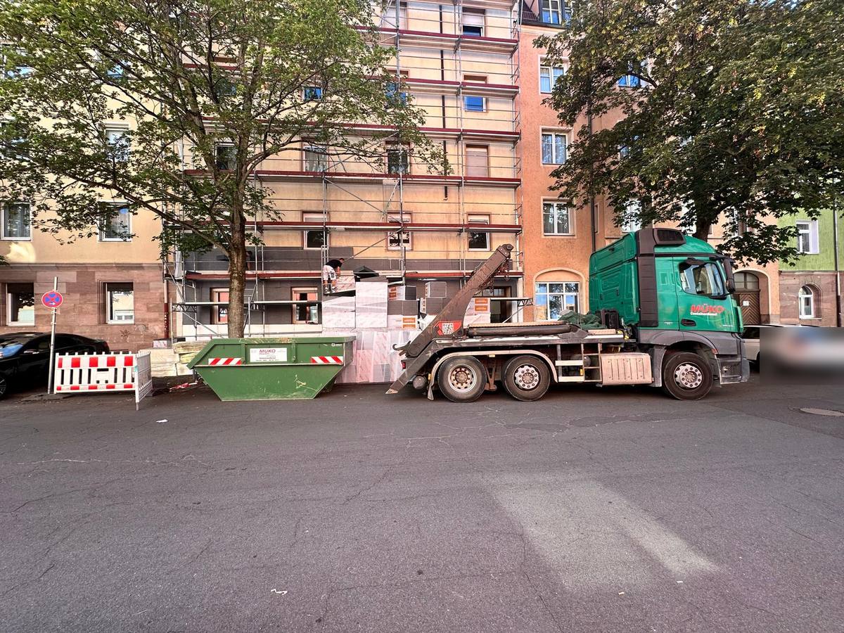 MÜKO Absetzkipper und grüner Absetzcontainer bei einer Fassadensanierung in Nürnberg
